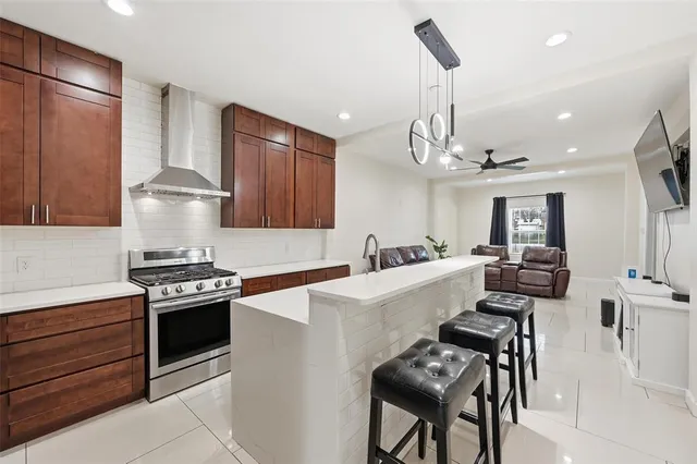 a kitchen with stainless steel appliances a stove a sink island and a refrigerator