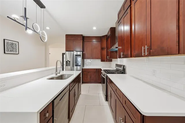 a kitchen with a sink stove and cabinets