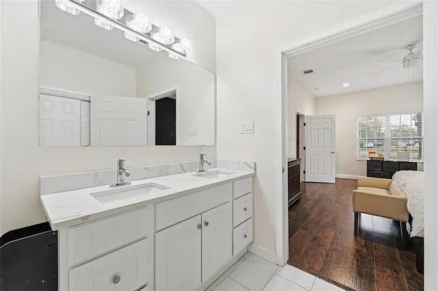 a spacious en suite bathroom with double sink and a mirror