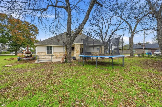 a white house with a large tree next to a yard