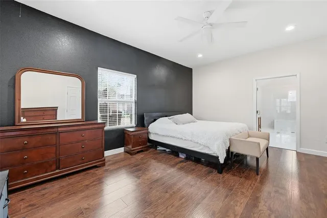 a spacious bedroom with a bed and a dresser