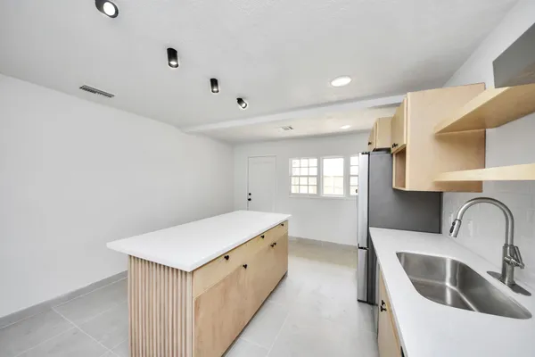 a kitchen with white cabinets a sink and dishwasher