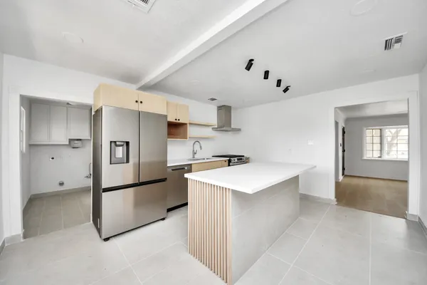 a kitchen with stainless steel appliances a refrigerator and a stove top oven