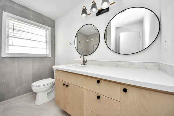 a bathroom with a toilet a sink and a mirror