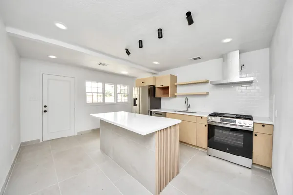 a kitchen with a stove a sink and a refrigerator