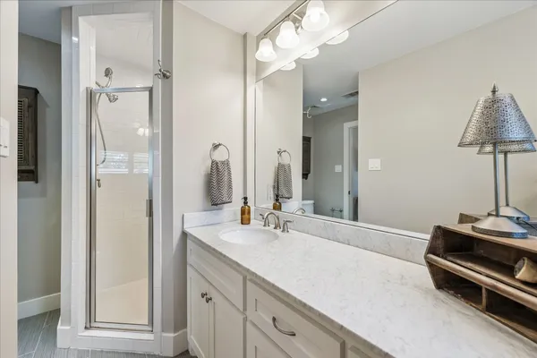 a bathroom with a double vanity sink mirror and shower