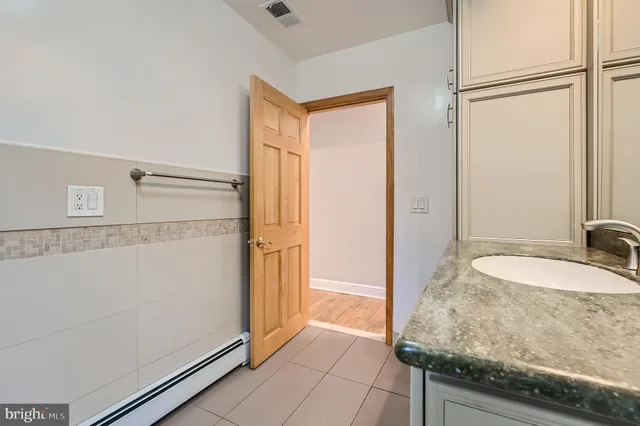 a bathroom with a granite countertop sink and a mirror