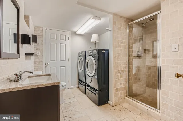 a bathroom with a granite countertop sink a mirror and shower