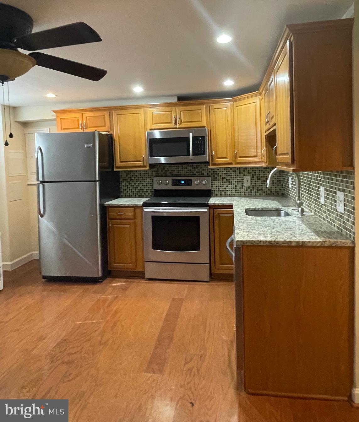 a kitchen with stainless steel appliances granite countertop a stove a sink and a refrigerator