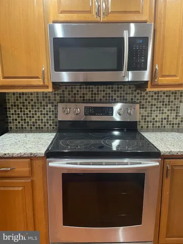 a stove top oven sitting inside of a kitchen