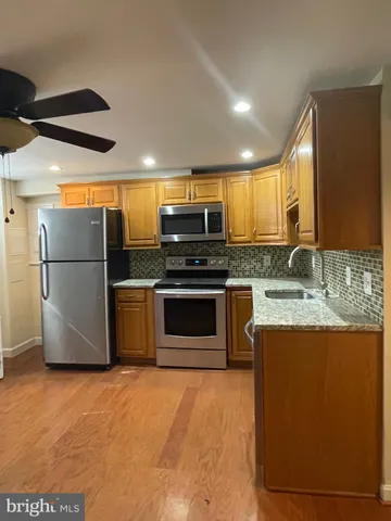 a kitchen with stainless steel appliances granite countertop a refrigerator a stove a sink and a microwave