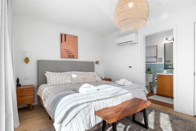 a bedroom with a bed and a flat tv screen on dresser