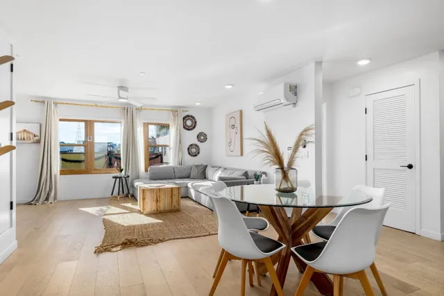 a kitchen with stainless steel appliances granite countertop a refrigerator a sink a stove a dining table and chairs