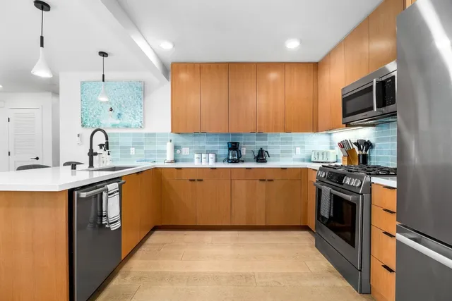 a kitchen with stainless steel appliances granite countertop a stove microwave and refrigerator