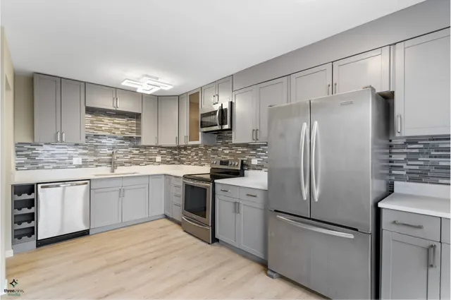 a kitchen with stainless steel appliances granite countertop a refrigerator stove a sink and dishwasher