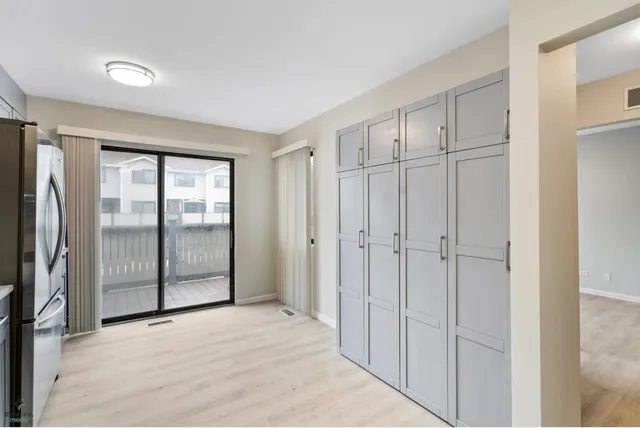 an empty room with floor to ceiling window and closet area