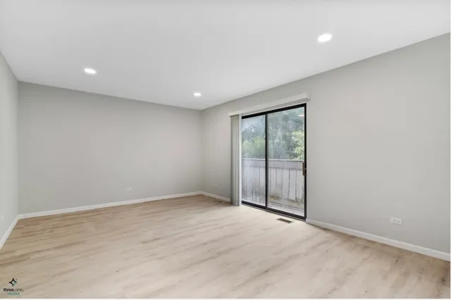 an empty room with wooden floor and sliding door