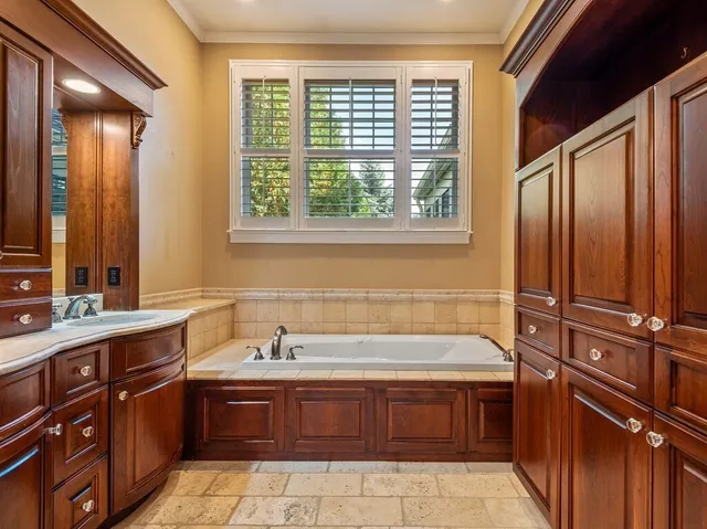 a bathroom with a tub sink and mirror