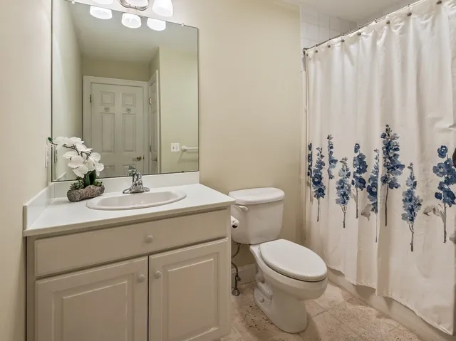 a bathroom with a sink vanity mirror and toilet