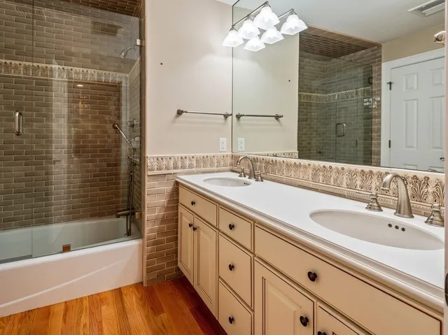 a bathroom with a double vanity sink mirror and bathtub