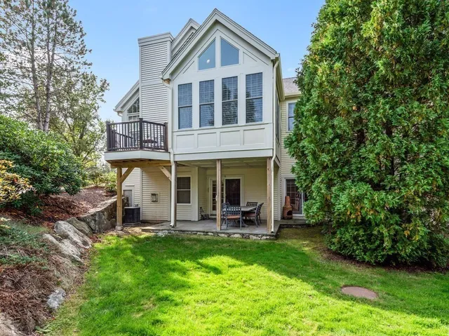 a view of a house with a yard and lawn chairs with a fire pit