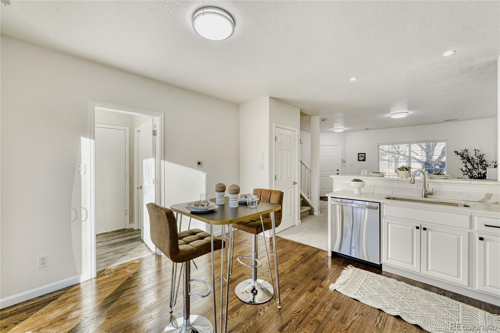 6130 Gorham Street Frederick, CO 80530 - Photo 15 of 47 a view of a kitchen area with furniture and wooden floor
