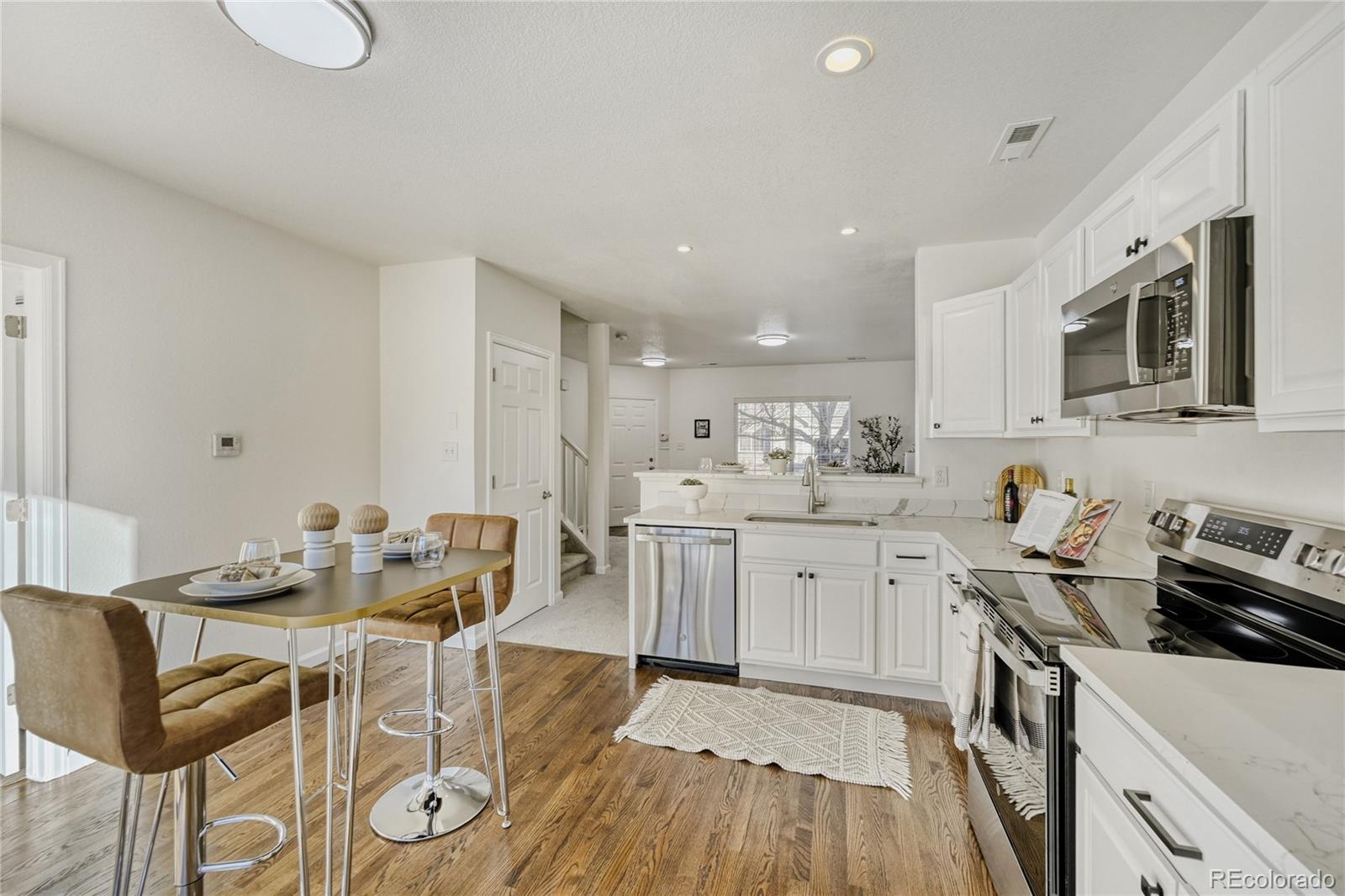 6130 Gorham Street Frederick, CO 80530 - Photo 16 of 47 a kitchen with furniture wooden floor and stainless steel appliances