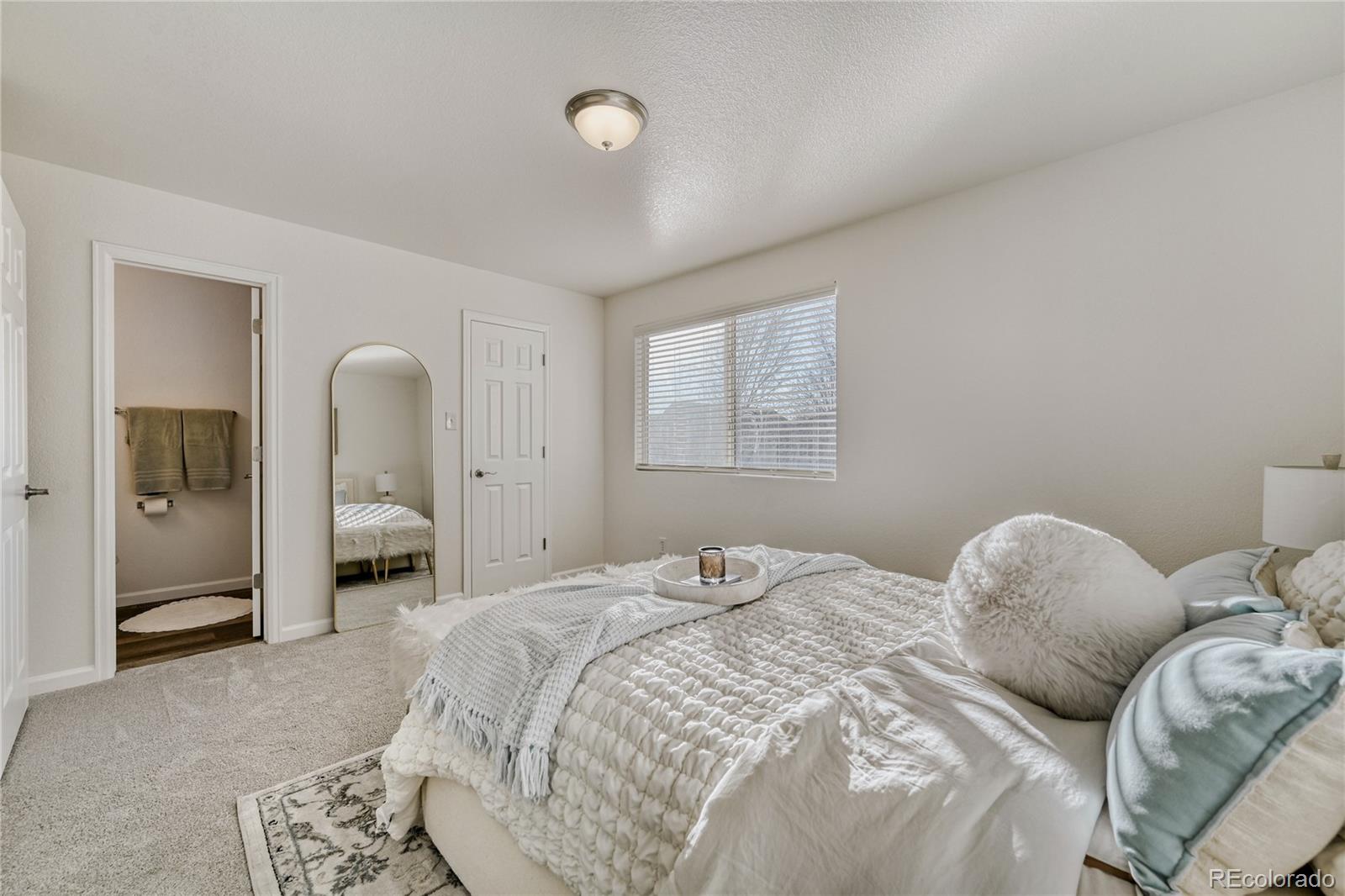 6130 Gorham Street Frederick, CO 80530 - Photo 25 of 47 a bedroom with a bed and a chandelier
