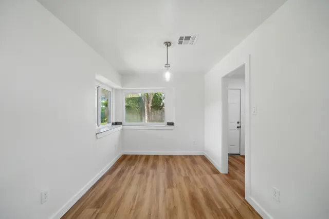 a view of a room with wooden floor and windows