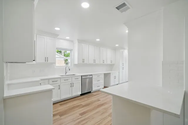 a large kitchen with cabinets and wooden floor