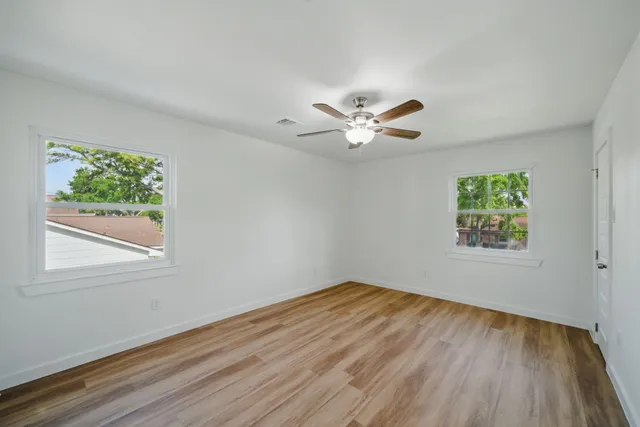 a view of a big room with wooden floor and a window