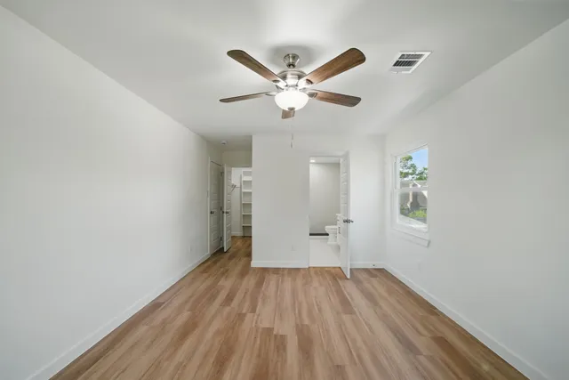 a view of empty room with wooden floor