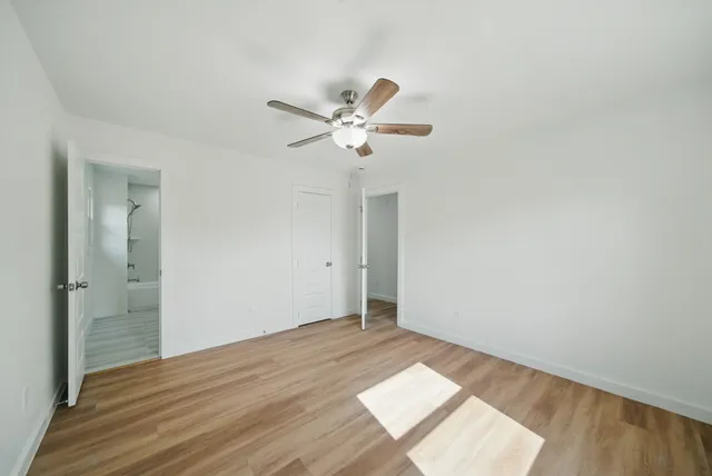 a view of a workspace with wooden floor and a ceiling fan