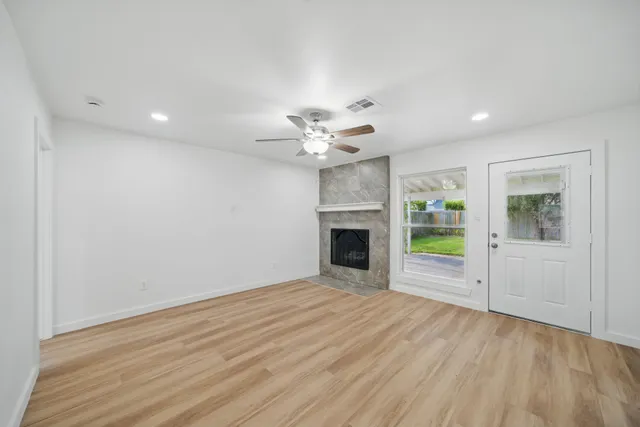 a view of an empty room with a fireplace and a window