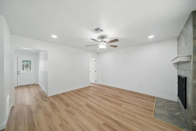 a view of an empty room with wooden floor