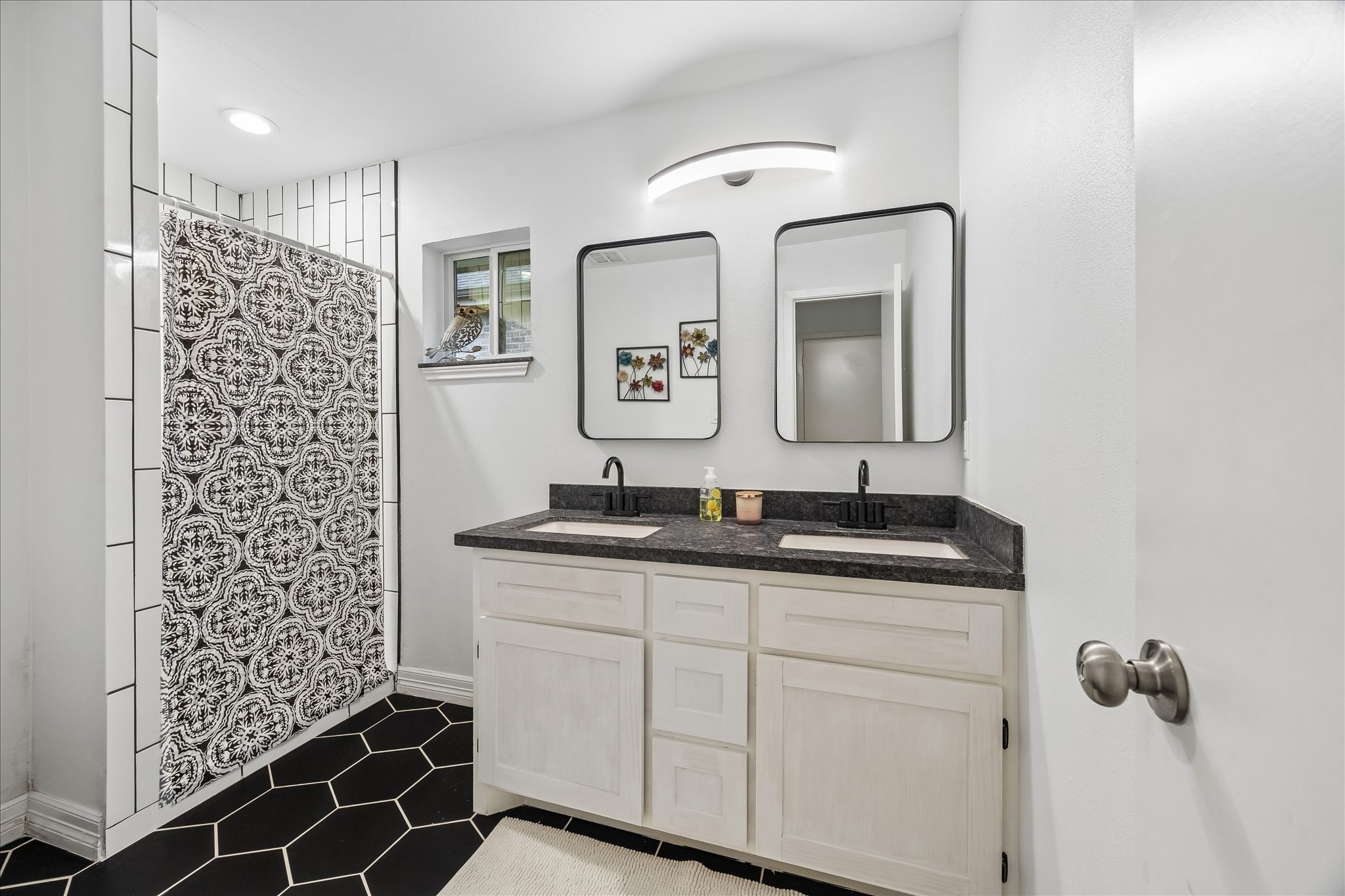 5526 Grape Street Houston, TX 77096 - Photo 6 of 10 a bathroom with a granite countertop sink a mirror a vanity and a shower
