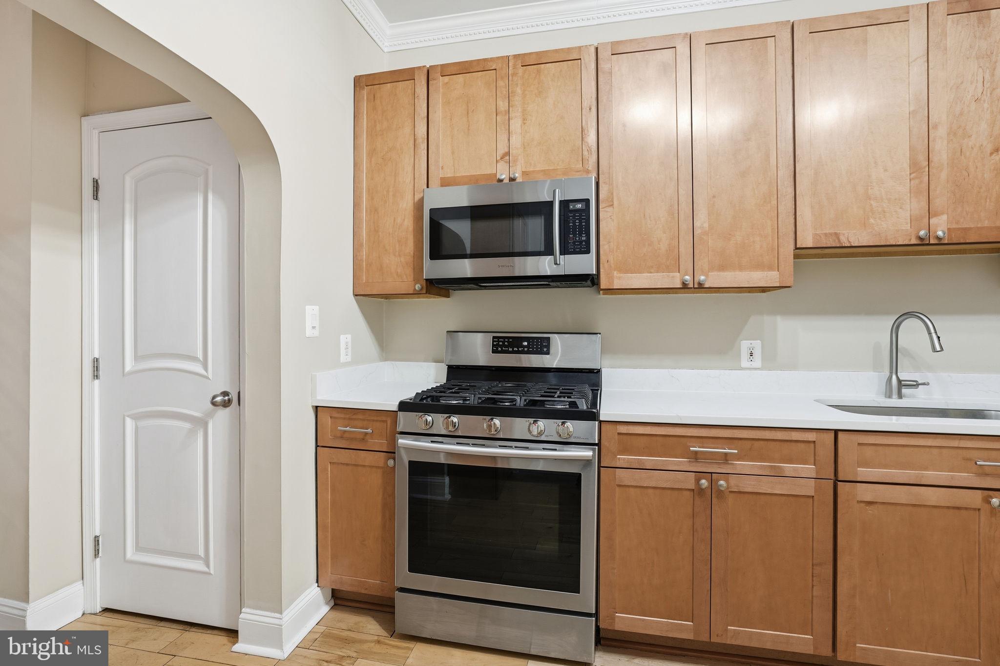 107 West Fort Avenue Baltimore, MD 21230 - Photo 15 of 34 a kitchen with white cabinets and stainless steel appliances