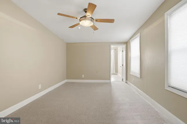 an empty room with fan and a ceiling fan