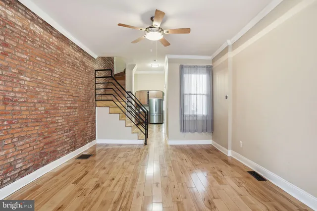 a view of a hallway with wooden floor and staircase