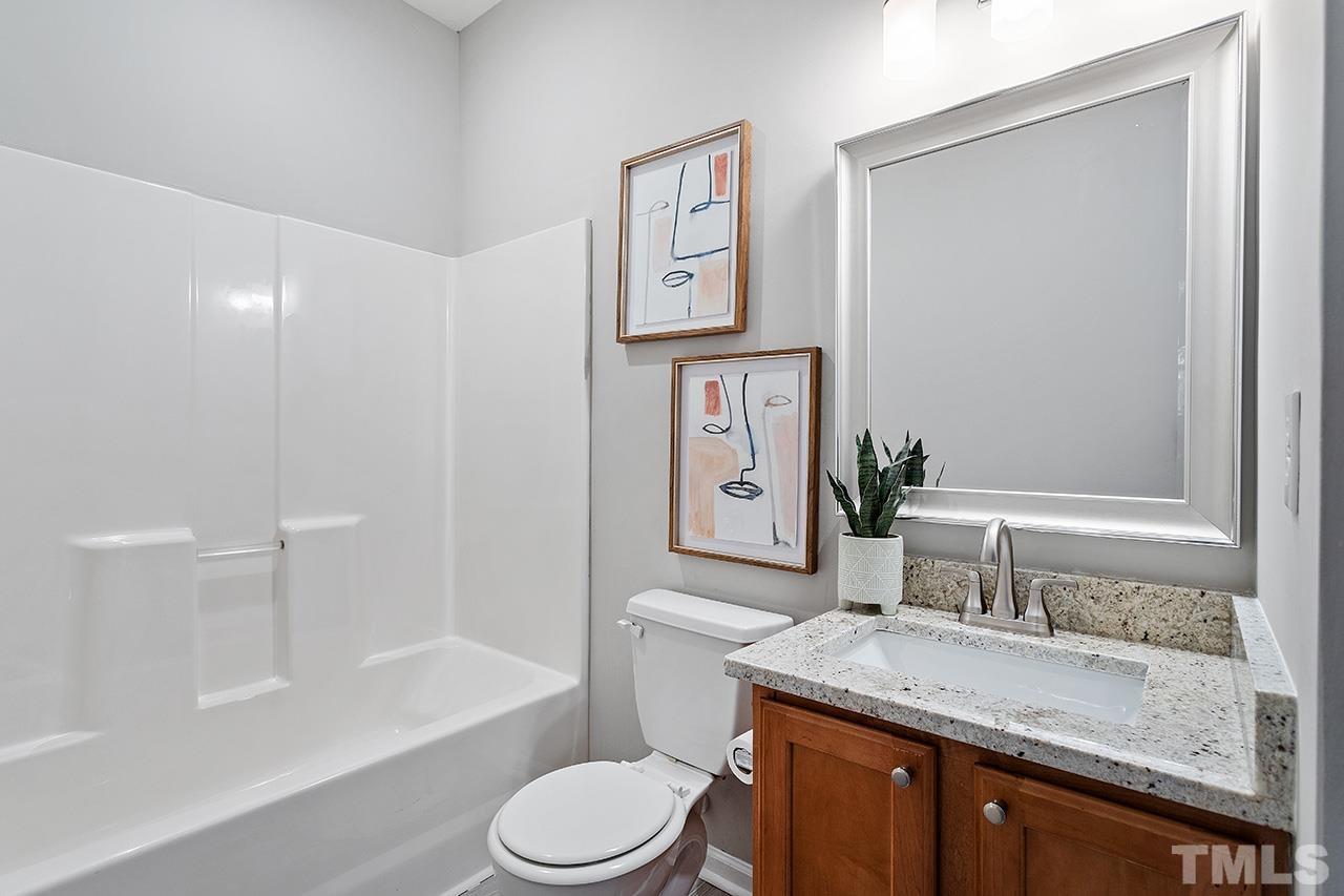 8516 Micollet Court Raleigh, NC 27613 - Photo 14 of 26 a bathroom with a granite countertop sink toilet and shower