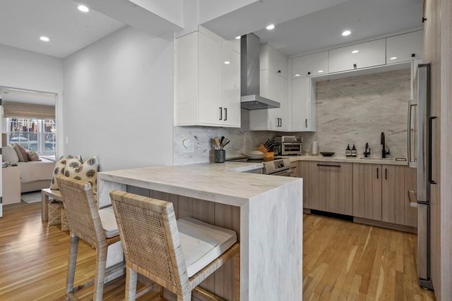 a kitchen with kitchen island a stove a table and chairs in it
