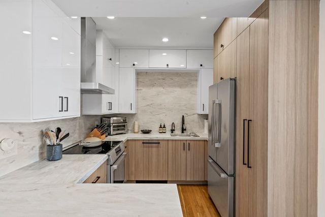 a kitchen with stainless steel appliances granite countertop a sink a refrigerator and a stove