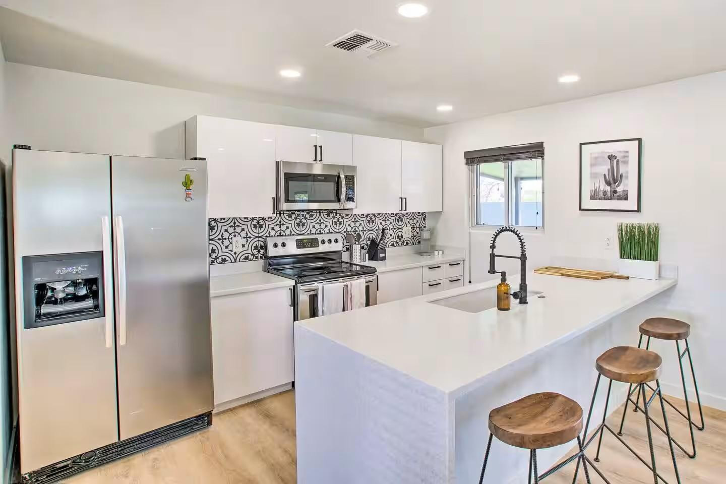1233 East Marny Road Tempe, AZ 85288 - Photo 7 of 20 a kitchen with stainless steel appliances kitchen island a refrigerator and a stove top oven with white countertops