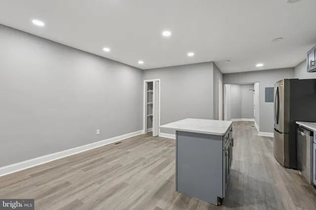 a view of a kitchen with refrigerator and wooden floor