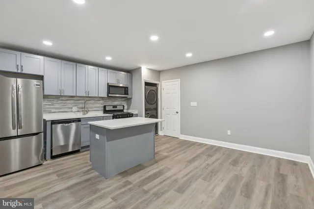 a kitchen with granite countertop a refrigerator and a stove top oven