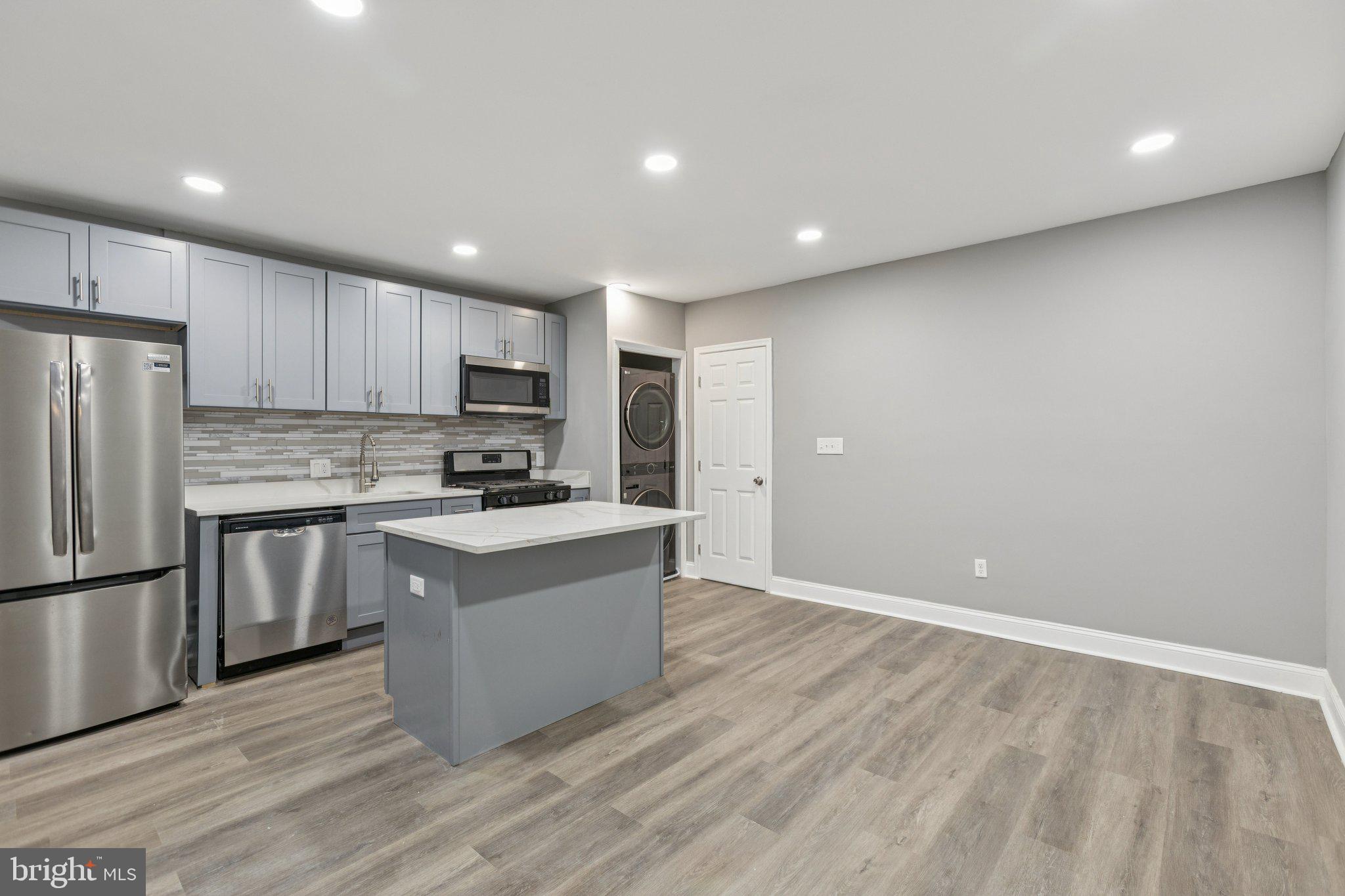 405 34th Street Southeast, Unit 2 Washington, DC 20019 - Photo 5 of 13 a kitchen with granite countertop a refrigerator and a stove top oven