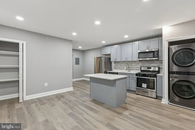 a kitchen with kitchen island a stove a sink and a refrigerator