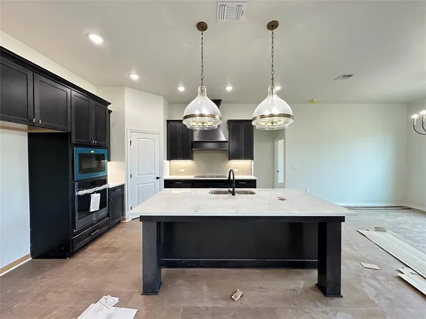 a large kitchen with a table and chairs