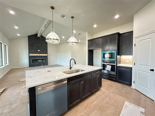 a kitchen with a sink a counter space cabinets and stainless steel appliances