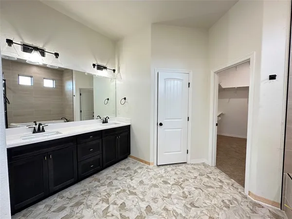 a spacious bathroom with a sink and a mirror